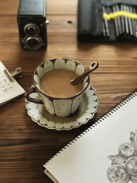 cup of coffee and a book on a wooden background