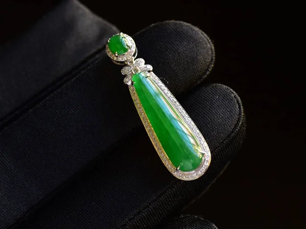 green jewelry with diamonds on black background