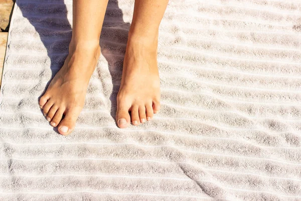 child bare feet with dry skin on towel cloth background textured surface under bright sun lighting on a beach, empty copy space for your text