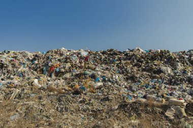 huge dump garbage hill and blue sky empty copy space for your text or inscription, environmental pollution and global ecology disaster concept photography  clipart