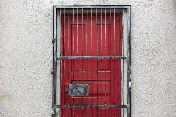 Червона Дверна Рамка Зачиненою Масивною Залізною Решіткою Зовнішньому Фоні Бетонної — стокове фото