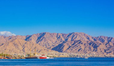 Akabe Körfezi Kızıldeniz Koyu İsrail limanı Eilat şehrinde gemileri olan Orta Doğu Çölü manzaralı Ürdün dağları manzaralı arka plan