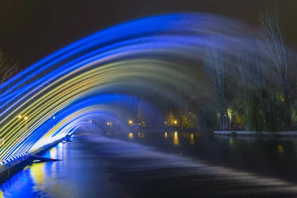 Lange Belichtung Brunnen Bäche Durch Blaue Und Gelbe Scheinwerfer Städtischen — Stockfoto