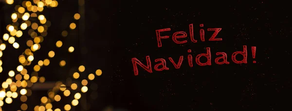 メリークリスマス スペイン語のテキストの碑文のポストカードの冬の休暇のコンセプトは 庭の照明や黒の背景に輝くから黄金のボケ — ストック写真