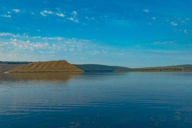 Doğa rezervasyonu. Huzurlu manzara manzarası. Göl manzarası. Pürüzsüz su yüzeyi ön plan ve tepeler. 