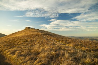 Ukrayna Karpat Dağları 'nın görkemli renkli dağlık manzarası vadi sarı çimenler açık havada karaya çıkar güneş ışığı ve mavi gökyüzü bulutu gün batımından önce 