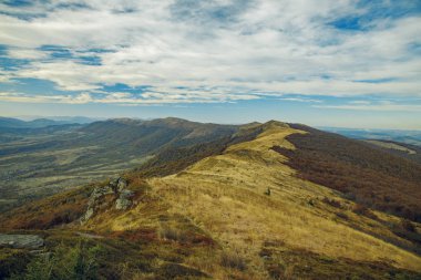 Sonbahar soğuk havasının kayalık taşları ve kahverengi renkleri ile dağlık dramatik dağ sırasının gökyüzü manzarası 
