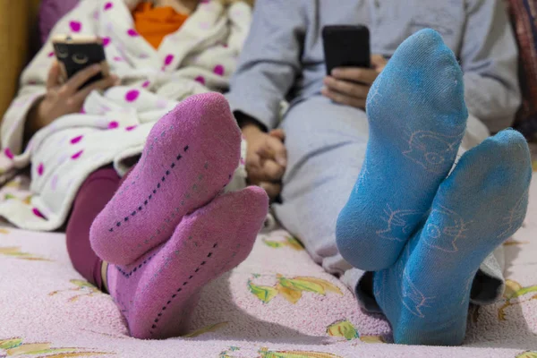 İş günü sahnesinden sonra dinlenen rahat bir gece. Gül çoraplı kadın ve mavi çoraplı adam, bulanık arka plan.