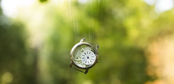 延长时间的平面设计概念手钟运动在空气中对模糊的 不聚焦的 绿色的 自然的背景的影响 — 图库照片