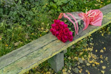 Kırsal ahşap bankta terk edilmiş gül buketi rengarenk depresyon fotoğrafçılık kırık ilişki konsepti 