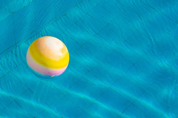 swimming pool and inflatable rubber light ball floating on smooth water surface wallpaper poster concept picture of summer clear weather day time, empty copy space for your text