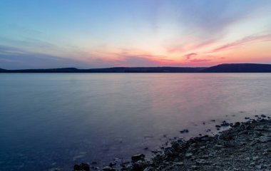 Akşam gölü kıyısı hattının uzun pozlu manzara fotoğrafçılığı sessiz barışçıl manzara duvar kâğıdı deseni ve metin için boş kopya alanı 