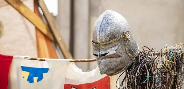fake knight helmet on medieval reconstruction festival blurred unfocused background