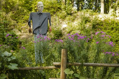 Gülümse korkuluk kırsal el tarımsal bahçe çitleriyle çevrili yeşil yeşillikler güneşli yaz mevsiminde açık havada doğal ortam için bir nesne yaptı.  