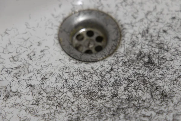 disgusting bathroom soft focus view with shaved hairs in white sink