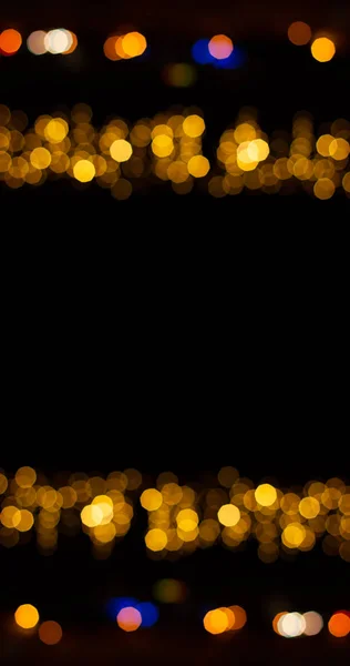 holidays simple colorful pattern golden Christmas lights bokeh illumination frame on black background empty copy space for your text here in vertical picture