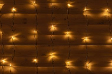 Çelenk ışıkları ahşap güverte duvarı sade şenlikli arka plan dekorasyonu alacakaranlık aydınlatmasında şablon oluşturur 