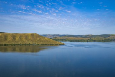 Doğa manzarası duvar kâğıdı manzara manzarası yazın huzurlu göl suyu ve yeşil sarı tepeler açık mavi gökyüzü.