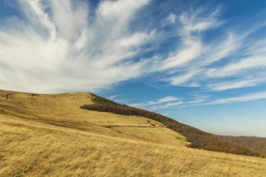 Dağlar kuru çimler dağlık arazi manzaralı fotoğrafçılık açık hava zamanı ve canlı mavi gökyüzü pofuduk beyaz bulutlar arka plan
