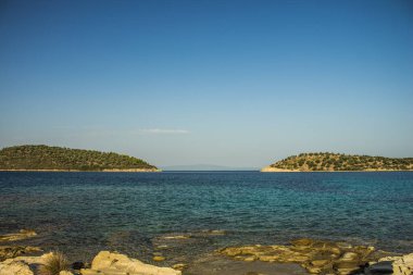 Sakin bir yaz zamanı olan Ege Koyu Güney Avrupa 'da kayalıklarla kaplı kıyı şeridi önü ve adaların açık hava gününde arka planı, kopyalama alanı