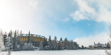 Kayak merkezi otel daireleri kış zamanı orman peri masalı manzarası çevresi donmuş göl kenarında kar yağışı havası, kopyalama alanı