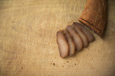 Basturma çiğ tütsülenmiş at eti Ermeni geleneksel mutfak tabağı dilimleri ahşap dokuma tahtada, metin için kopyalama alanı burada