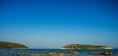 Yaz zamanı, ana kara fotoğrafçılığının yakınındaki küçük ada Atlantik okyanus manzarasının huzurlu manzarası kayalık kaya kıyı şeridinden, metnin için kopyalama alanı.