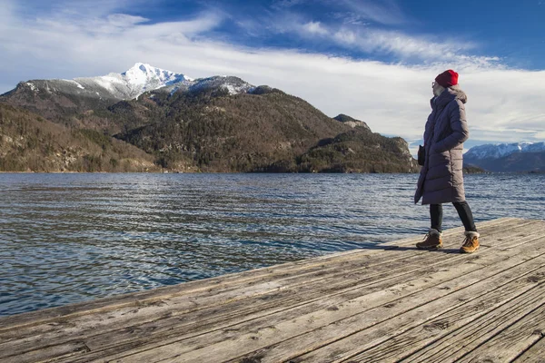 Viagens estilo de vida fotografia de Instagram localização dominante Hallstatt Áustria menina posando virar e desfrutar de idílica paisagem pitoresca tempo de inverno com pico de montanha nevado e lago — Fotografia de Stock