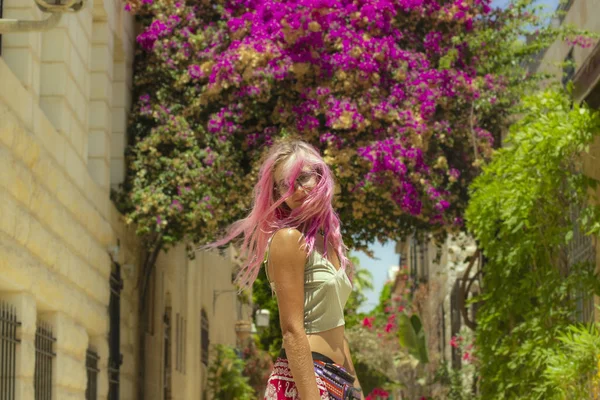Kız canlı pembe saçlar, hareketli açık hava ifadesi, bahar mevsiminde kadın portresi fotoğrafçılığı, Kudüs 'ün çiçek açan şehir manzarası. — Stok fotoğraf