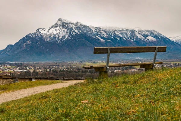 Alpen Berge Landschaft schneebedeckter Bereich Gipfel Hintergrund mit einsamen Holzbank Vordergrund schöner Aussichtspunkt friedliche und einsame Atmosphäre im Frühling, Kopierraum — Stockfoto