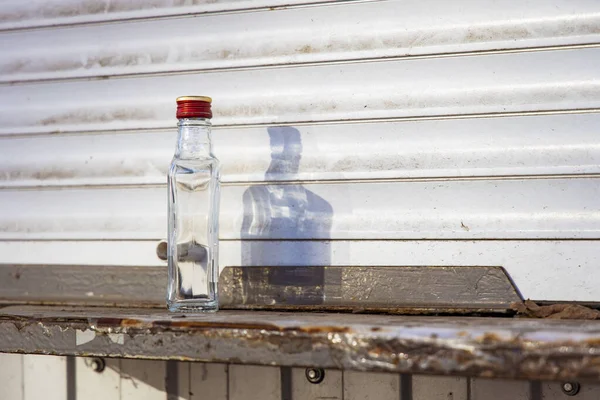 Problema de álcool garrafa de vidro vazia em ambiente urbano sujo fundo, espaço de cópia — Fotografia de Stock
