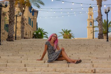 Tel Aviv 'in başkenti yakınlarındaki eski bir İsrail şehrinin Jaffa merkez sokağındaki merdivenlerde poz veren genç bir kızın kadın portresi.