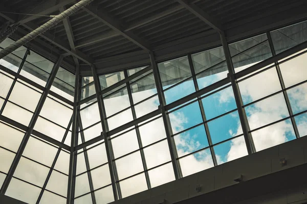 Tovární hala uvnitř pohled na moderní průmyslové architektury bílé a šedé stěny a trubky s okenním rámečkem s oblačným výhledem na pozadí oblohy — Stock fotografie