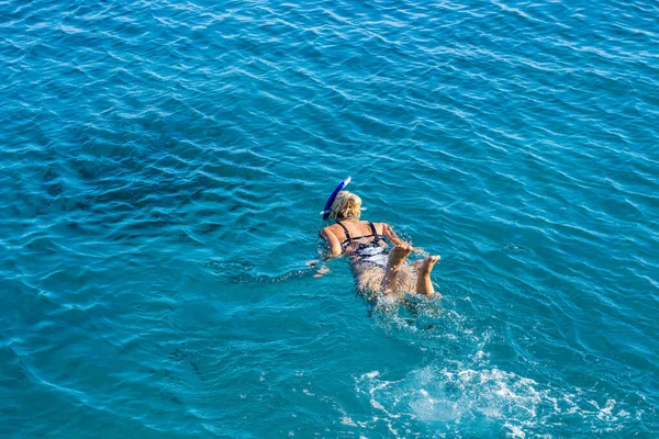 Vista aérea menina natação em mar vermelho águas azuis claras verão tempo férias conceito papel de parede banner com espaço de cópia vazio para texto — Fotografia de Stock