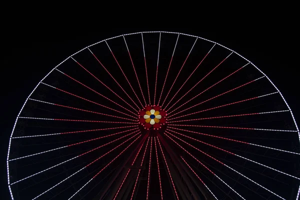 Ferris rueda iluminación rojo oír forma carnaval santo San Valentín vacaciones concepto en la noche oscuridad negro fondo, espacio de copia — Foto de Stock