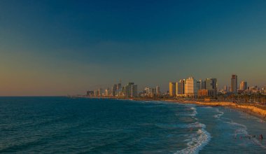 İsrail 'in Tel Aviv başkenti yaz zamanı tatil sezonu manzarası manzara manzarası akşam romantik ışıklandırma modern şehir gökdelenleri kıyı şeridi ve Akdeniz kıyısı manzarası