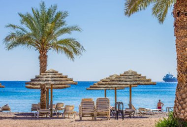 Yaz tatili Palm Beach hasır şemsiyesi güney tropik manzaralı kıyı şeridi Akabe Körfezi Körfezi