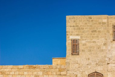 Ortaçağ taş duvarı, kapalı ahşap kepenkler, köşe çerçeve geometrik çerçeve, arka plan duvar kâğıdı konsept fotoğrafçılık, boş mavi gökyüzü ve metin için boşluk.