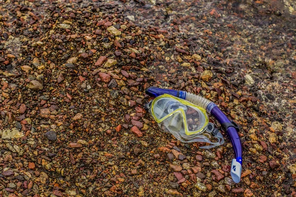 Μάσκα δραστηριότητας ψαροντούφεκου και στοιχειώδης εξοπλισμός σωλήνων σε θρυμματισμένο πετρώδες βραχώδες φόντο παραλίας — Φωτογραφία Αρχείου