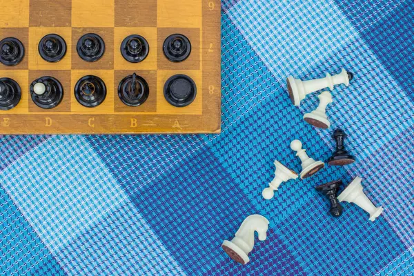 Escorzo creativo desde arriba concepto de ajedrez con escritorio de madera con figuras en blanco y negro en el espacio de juego y se encuentran cerca de la textura del fondo de la alfombra, espacio de copia para su texto — Foto de Stock