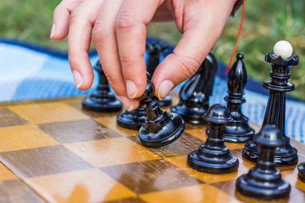 Concepto del primer paso de la mano humana en la figura de peón de ajedrez negro — Foto de Stock