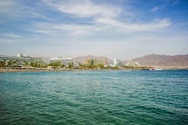 summer time vacation season destination Middle East Israeli city Eilat on Red sea bay Gulf of Aqaba port hotel district waterfront side with water foreground, copy space for your text