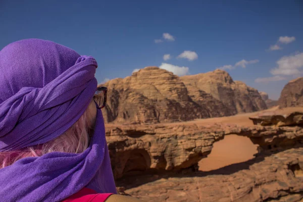 Resor fotografi kvinna i hijab tittar på Wadi Rum öken pittoreska landskap med sand sten stenar och bro naturlig arkitektur form bakgrund natursköna vyn Östra turistiska arvet webbplats — Stockfoto