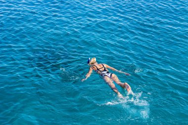 Yaz tatilinde deniz manzaralı mavi sularda yüzen kadın manzaralı arka plan duvar kâğıdı desenli boş fotokopi alanı.