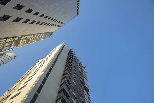 Edificio moderno común fachada exterior torre estructura de construcción escorzo desde abajo sobre fondo de cielo azul vacío — Foto de Stock