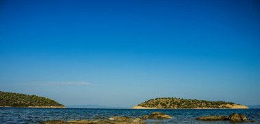 Yaz zamanı, ana kara fotoğrafçılığının yakınındaki küçük ada Atlantik okyanus manzarasının huzurlu manzarası kayalık kaya kıyı şeridinden, metnin için kopyalama alanı.
