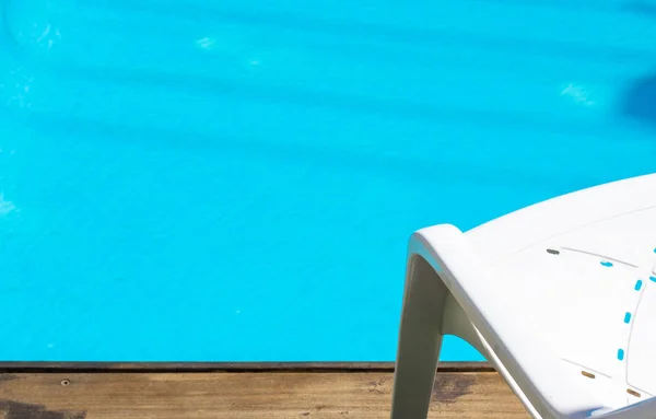 ホテルプールヤードリラクゼーション屋外スペース壁紙パターンの写真白椅子と青の水の背景、コピースペース — ストック写真
