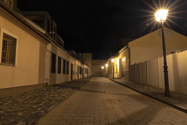 Húsvét Európai éjszaka város utca kövezett út sikátor hosszú expozíció mérföldkő fotózás régi épületek és lámpás villany fény, nincs ember itt — Stock Fotó