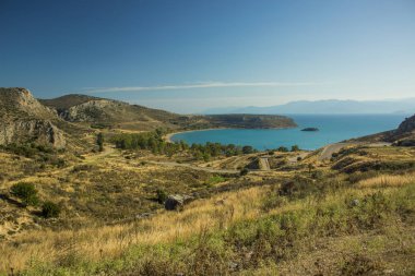 Yunanistan 'ın Mora yarım adasında Akdeniz kıyısına uzanan kavisli otomobil yolu olan manzaralı sarı kayalık tepeler