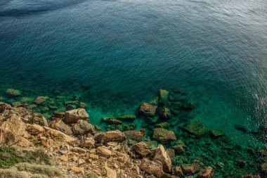 tropic vivid colorful mountain rocks and blue green water surface with waves from above in warm colorful summer day weather